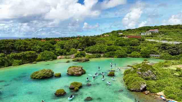 きれいな沖縄の海でサップをしている団体の画像